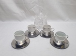 Lote de açucareiro em vidro, 4 xícaras de café em porcelana com suporte e pires em aço inox. Medindo o açucareiro 9cm x 14cm de altura.