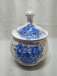 Potiche bojudo com tampa em porcelana com pintura floral azul. Medindo 15cm de boca x 15,5cm de altura sem tampa.
