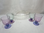 Travessa oval em vidro temperado com 4 taças de sobremesa em plastico duro. Medindo a travessa 35cm x 23cm x 9cm de altura. Com pequenos bicados.