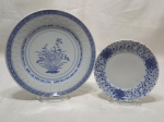 Lote de 2 pratos decorativos em porcelana azul e branca, sendo uma Polovi Germer e uma oriental. Medindo o maior 23cm de diâmetro.