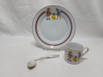 Kit infantil, sendo um prato e uma caneca em porcelana e colher torta em prata 90. Medindo o prato 21cm de diâmetro.