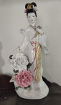 Grande estatueta em porcelana representando gueixa com flores. Rico trabalho em delicada porcelana.