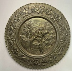 091 Grande medalhão, Século XX, em metal prateado, representando folhas de parreira e colheita de uv