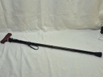Bengala em metal com regulagem de altura, pega em madeira e ponteira de borracha. Medindo 93cm max x 83cm min.