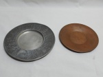 Lote de 2 pratos, sendo um em metal prateado com relevos e um em metal dourado cinzelado. Medindo o maior 18cm de diâmetro.