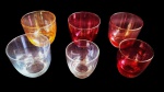 Seis copos para licor em vidros coloridos iridescente. Dois deles de tamanho menores.