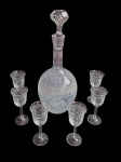 Licoreira em cristal, acompanhada de  6 taças adornada ricamente por lapidação fina e elegante. Garrafa apresenta mofo e bicado na borda.