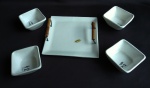 Bandeja de porcelana com alças contendo 4 potes também de porcelana para molhos japoneses. Apresentam fios de cabelo no fundo dos potes. Medida da bandeja 17x17cm.