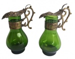Antigo e delicado  par de galeteiro em forma de ânfora, composto de corpo em vidro verde e guarnições em metal, adornada de guirlandas e uvas em relevo. Medidas 12cm.