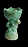 Enfeite de porcelana representando querubim levando cestos de uvas. Medida 23cm de altura.