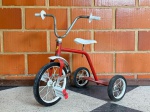 COLECIONISMO - VINTAGE - Velocípede em ferro tubular pintado de vermelho, assento em chapa de metal pintado de branco. Manufatura Bandeirante. Década de 60. Marcas do tempo e de uso.