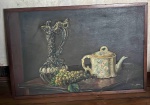 Quadro com cacho de uvas, bule e outro utensílio sobre uma mesa de madeira em moldura de madeira - dim - 84x57x2