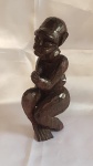 Escultura em jacarandá com forte influencia Africana representando pessoa "Acocorada" medindo 26 cm por 10 cm por 9 cm.