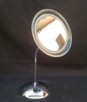 Espelho de mesa com luminária em metal cromado. Funcionamento a pilha, não testado. Alt. 37 x diam. 6cm.