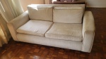 Sofá de 2 lugares revestido em tecido bege. Apresenta sinais do tempo, necessitando limpeza, medindo 75 cm de altura no encosto x 176 cm de comprimento x 90 cm de profundidade. Retirada na rua Senador Vergueiro com agendamento.