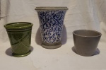 Três vasos sendo o maior medindo 28 cm de altura  por 23 cm de diametro em cerâmica marrom com bojo esmaltado ao gosto oriental azul e branco e interior policromado de cinza apresenta mínima falta na base acompanha outro em faiança esmaltada de verde com libélula em relevo medindo 21 cm por 16 cm .