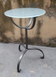 Mesa de apoio em ferro pintado com tampo em vidro satinado medindo 72 cm de altura por 45 cm de diâmetro.