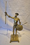 Escultura em metal amarelo representando Don Quixote medindo 36 cm de altura por  15 cm por 10 cm.
