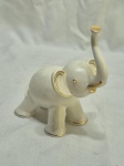 Escultura na forma de elefante em porcelana com detalhes ouro, peça assinada. Medindo 13cm x 15cm de altura.