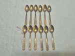 Jogo de 12 colheres de café em metal dourado. Medindo 10,5cm de comprimento.