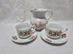 Lote de leiteira com 2 xícaras de chá em porcelana. Medindo a leiteira 14cm de altura.