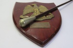 MILITARIA - BASTÃO DE COMANDO e PLACA de Parede DE PRESENTEAÇÃO do Exército Indiano ao GENERAL LYSENO SARMENTO (não consta seu nome), datada de 1964/1965, quando comandava a faixa de Gaza e o Sinai. O Bastão mede aprox. 54 cm de comprimento. Siseno ou Syseno Ramos Sarmento foi um militar do Exército Brasileiro que serviu na Força Expedicionária Brasileira, atuou como interventor federal no Amazonas, comandou o II e o I Exército e encerrou a carreira como Ministro do Superior Tribunal Militar. Foi um destacado general do Exército Brasileiro, cuja trajetória militar se entrelaça com momentos cruciais da história do Brasil no século XX. Como primeiro-tenente, participou da Revolução de 1930, que levou Getúlio Vargas ao poder. Em 1932, combateu a Revolução Constitucionalista em São Paulo. Promovido a capitão em 1933 e a major em 1942, comandou o 21º Batalhão de Caçadores em Garanhuns. Durante a Segunda Guerra Mundial, liderou o 2º Batalhão do 1º Regimento de Infantaria, conhecido como Regimento Sampaio, na Campanha da Itália. Destacou-se na Batalha de Monte Castelo, onde seu batalhão teve papel crucial na vitória brasileira.