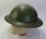 MILITARIA - CAPACETE M1917 `DOUGHBOY` – Exército Americano, Primeira Guerra Mundial. Este capacete é o clássico M1917 `Doughboy`, usado pelo Exército dos Estados Unidos durante a Primeira Guerra Mundial e nos primeiros anos da Segunda. Inspirado no modelo britânico Brodie, o M1917 foi a primeira proteção padrão emitida aos soldados americanos em larga escala. Seu formato em `tigela` com aba estreita visava proteger contra estilhaços e impactos vindos de cima, comuns nas trincheiras. O apelido `Doughboy` se refere aos soldados americanos que o usaram no front europeu, especialmente na França a partir de 1917. A camuflagem pintada à mão no capacete da imagem indica que pode ter sido adaptado por seu portador durante manobras ou missões específicas. Embora rudimentar em comparação aos capacetes modernos, o M1917 representou um grande avanço em proteção pessoal para as tropas dos EUA. Ele permaneceu em serviço até o início da Segunda Guerra Mundial, quando foi gradualmente substituído pelo capacete M1. Hoje, exemplares originais do modelo Doughboy com pintura camuflada são peças raras e bastante valorizadas por colecionadores de militaria da Primeira Guerra Mundial. OBS: SEM A CARNEIRA.