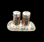 Conjunto de saleiro e pimenteiro em Alpaca, decorado com placas em Abalone. Med.: Bandeja: 9 x 5 cm