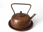 Grande chaleira com presentoir em cobre. Med.: Presentoir: 27,5 cm de diâm. Chaleira: 27 x 10 cm de altura (s/ alça); 20 cm de altura (c/ alça)