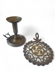 Lote composto por 1 castiçal palmatória e 1 descanso de panela em bronze. Med.: 21 x 13 x 2 cm de alt.; Palmatória: 13 cm de altura