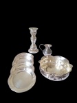 lote de metal prateado composto por: 1 cachepot ( 13,5 cm x 4,5 cm alt.); 1 castiçal ( 15 cm alt.); 1 pequena jarra (7 cm alt.); 5 descansos para copo ( 9,5 cm diâm.) * Apresenta pontos de desgaste no banho