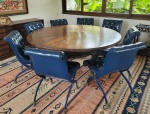 Conjunto de grande mesa redonda em madeira nobre com oito cadeiras forradas com couro verde em capto