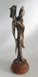 Escultura em metal cinzelado revestido de dourado representando oriental com sua lanterna. Base circular em madeira. Exemplar em excelente estado. Dimensões: 24 cm altura