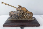Escultura em bronze representando tanque de guerra e base em madeira nobre, medindo 16 cm altura por 25 cm comprimento.