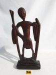 Escultura africana em madeira representando um nativo. A peça é assinada, porém não identificada. Medidas: 34,5 cm X 14 cm.