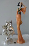 Conjunto composto por duas esculturas distintas: uma figura de gueixa em resina, e outra par de corujas prateadas (mãe com filhote) em resina. Ambas as peças exibem detalhes finos em suas expressões e trajes, cada uma com características únicas que enriquecem o conjunto. A escultura maior possui altura de 40 cm e a outra 23cm. Ideal para colecionadores e apreciadores de arte decorativa com toque clássico.