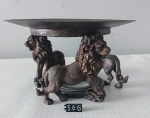  Exuberante este centro de mesa com base em resina representando leões, sobreposta por prato em metal patinado. Medindo total: 10x17,5 cm.