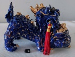 Estatua em porcelana azul e filetado á ouro representando dragão com belos detalhes. Medidas: Altura:14cm, Largura:10cm, Comprimento:20cm. OBS: apresenta alguns bicados.