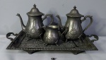 Antigo conjunto para chá marroquino, em metal prateado ricamente cinzelado, com belos trabalhos nas pegas composto de 01 bandeja 55x35,5cm, 2 bules e uma leiteira, marcas ao fundo.