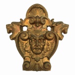Antiga  placa em Fer forgé , estilo Luiz XV,  decorado com volutas, perolados, concha e cabeças de seres mitológicos. Ao centro, rosto em alusão ao Rei Sol. Pesa aproximadamente 5 kg. Dimensões: 24 cm x 24 cm.