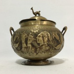 Antigo açucareiro em metal dourado decorado com folhagens, tocador de flauta. Presenças de marca do tempo. Dimensões: 13 cm x 15 cm x 12 cm.