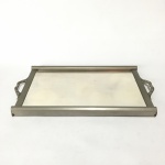 BARILI - Antiga Bandeja espelhada em metal cinzelado, formato retangular, com alças decoradas em arabescos. Pequenos sinais de desgaste. Dimensões: 26 cm x 46 cm.