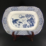 HALES, HANCOCK & GODWIN - ENGLAND - Antiga e bela travessa oval, cerca 1930, modelo ORIENT, em faiança esmaltada, decorada com cena central em tons de azul e borda floral. Borda  com restauro imperceptível. Dimensões: 40,5 x 28,5 cm x 3,5 cm.