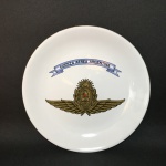Prato de coleção em porcelana esmaltada, decorado ao centro com emblema e inscrição " Força Aerea Argentina ".  Dimensões: 19 cm.