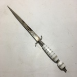 Belo punhal em metal cinzelado com cabo em acrílico branco com anéis em metal. Dimensões: 26 cm 
