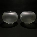 Belo par de cúpulas em vidro satinado, decorado com detalhes vegetalistas lapidados.Presença de pequeno bicado em um dos exemplares. Dimensões: 12 cm x 15 cm / abertura maior : 8,5 / abertura menor : 5