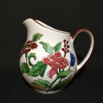 Delicada Jarra em porcelana ricamente decorada com arranjos florais pintados à mão. Exemplar assinado no fundo por Cecy e datado de 2001. Dimensões: 15 cm x 17 cm x 13 cm.