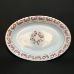 RIO BRANCO - Antiga travessa em porcelana esmaltada, decorada com detalhes vegetalistas na cor vermelho escuro e filetes à ouro. Dimensões: 24 cm x 34 cm x 4,5 cm.