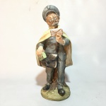 Antiga escultura de carteiro feita em massa de porcelana policromada. Dimensões: 24 cm.