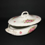 HUGHES LONGPORT ENGLAND - Antiga terrina em faiança do anos 40,  decorada com arranjos florais. Alças e pega no formato de folhas de acanto. Realces pintados à Ouro. Presença de craquelados. Exemplar de número 3942. Dimensões: 14 cm x 19 cm x 30 cm.